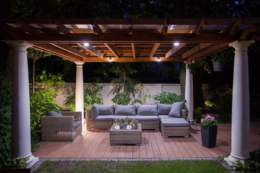 An outdoor gazebo area in a backyard well-lit via an outdoor lighting control system.