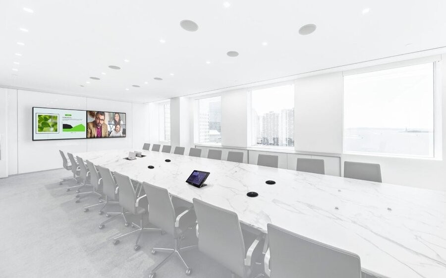 A conference room featuring a large screen and other AV solutions as part of a professional commercial AV design and setup.