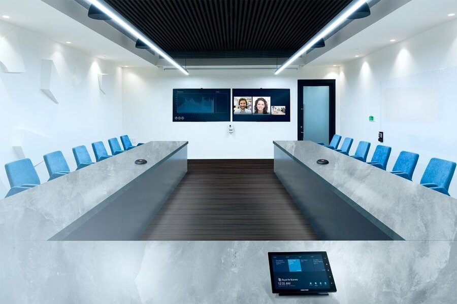 A large, empty conference room featuring various audio-video solutions from Crestron.